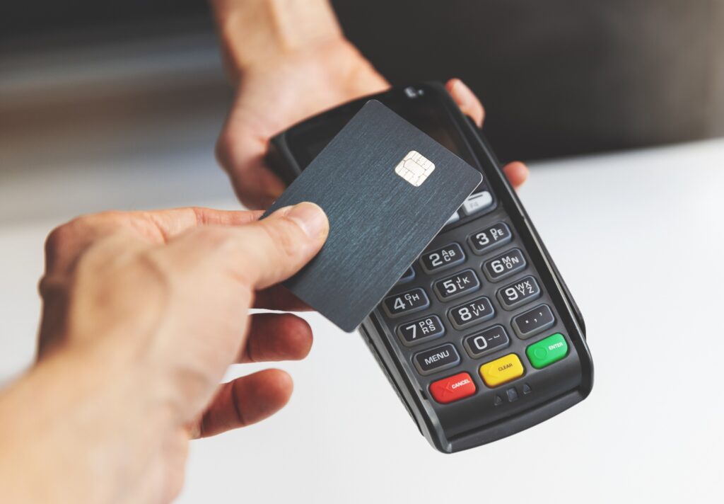 credit card held against a point-of-sale terminal